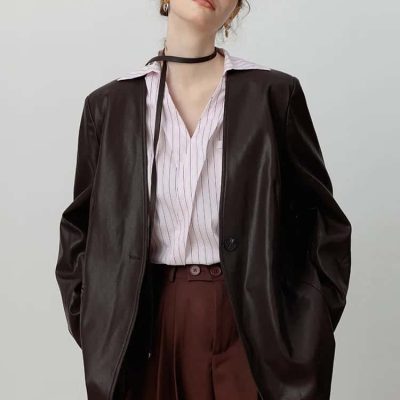 Stylish woman wearing black glasses, leather jacket, and tailored pleated trousers, showcasing modern fashion, beauty, and eyewear accessories, suitable for optometry fashion collections.