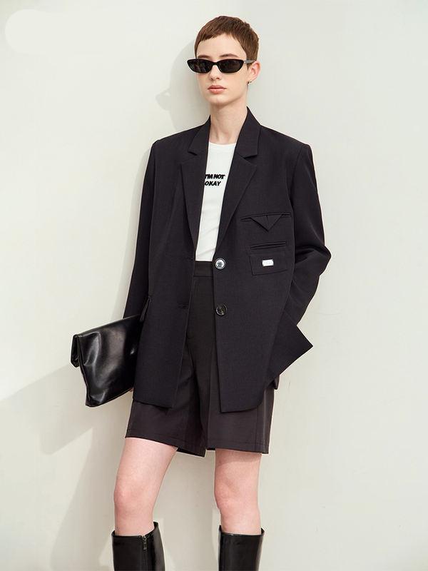 Black blazer with oversized fit, paired with black shorts and sunglasses, showcasing modern women's fashion at Monalisa Store. Perfect for stylish office or casual wear.