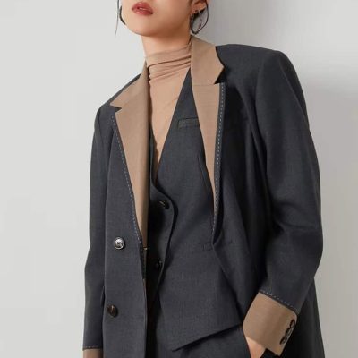 Elegant professional woman in a stylish suit showcasing Monalisa Store's fashionable eyewear collection in a modern retail environment.