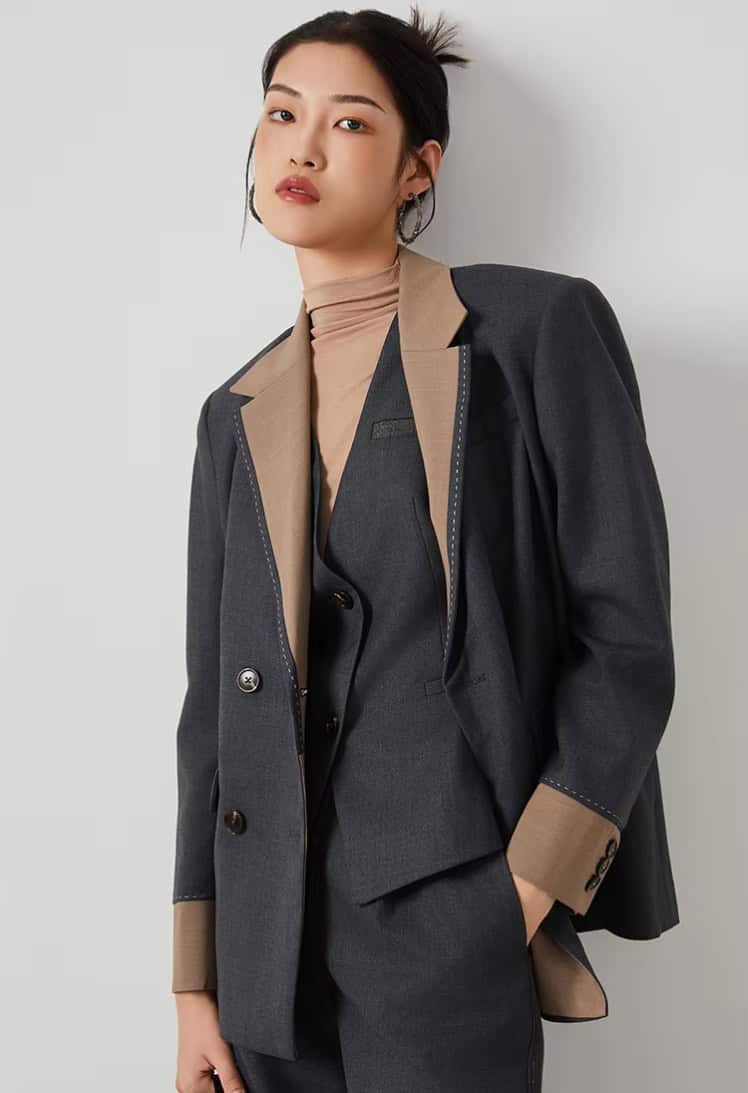 Elegant professional woman in a stylish suit showcasing Monalisa Store's fashionable eyewear collection in a modern retail environment.