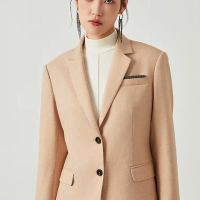 Blonde women in a beige blazer and white turtleneck, showcasing elegant professional office wear, perfect for formal fashion and business attire.