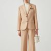 Elegant beige tailored women's suit, perfect for professional and formal occasions, featuring a fitted blazer and wide-leg trousers for a sophisticated look. Suitable for office wear or business meetings.