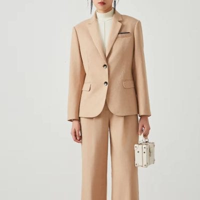 Elegant beige tailored women's suit, perfect for professional and formal occasions, featuring a fitted blazer and wide-leg trousers for a sophisticated look. Suitable for office wear or business meetings.