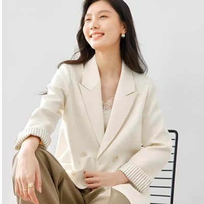Elegant woman wearing a cream blazer and beige pants, smiling confidently, representing stylish eyewear choices at Monalisa Store, ideal for promoting optical fashion and accessories.