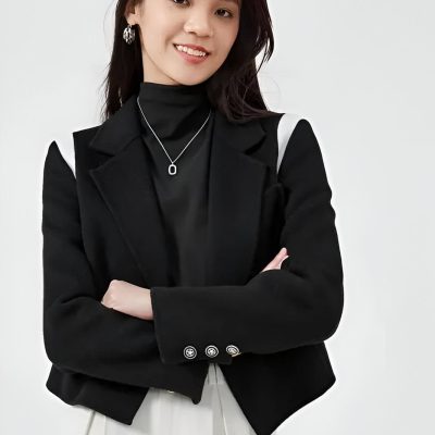 Stylish woman in black blazer and white pants, showcasing modern fashion with a sophisticated look perfect for professional or casual settings.
