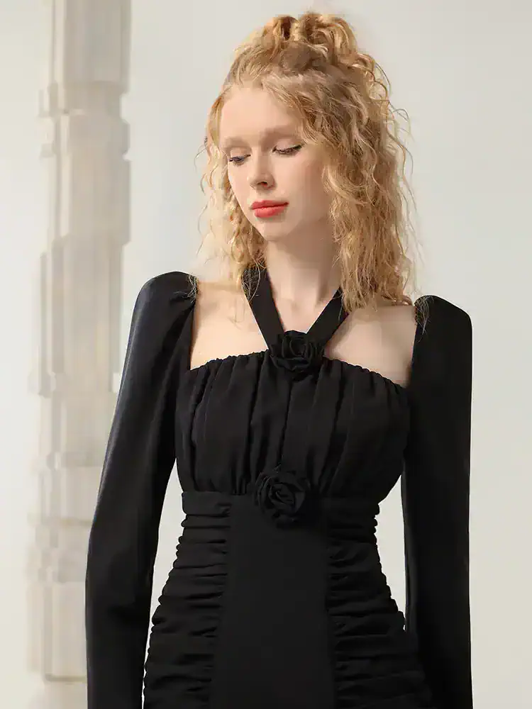 Elegant black evening dress with ruched detailing and floral accents, perfect for special occasions or formal events. Suitable for upscale fashion showcases and stylish women.