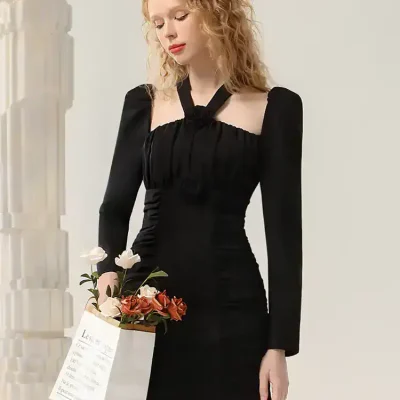 Elegant black dress with long sleeves and unique neckline, perfect for fashionable occasions or casual wear. Monalisa Medical offers stylish options for women seeking comfort and sophistication.