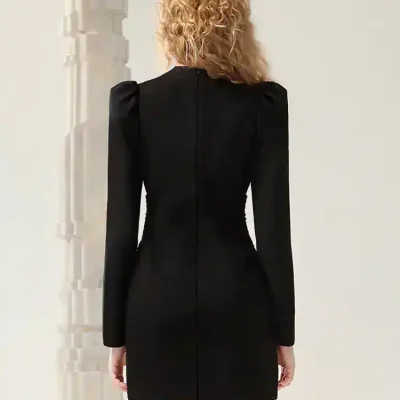 Elegant black dress with structured shoulders and fitted silhouette, perfect for formal occasions or stylish events. Designed with attention to detail for a sophisticated look.