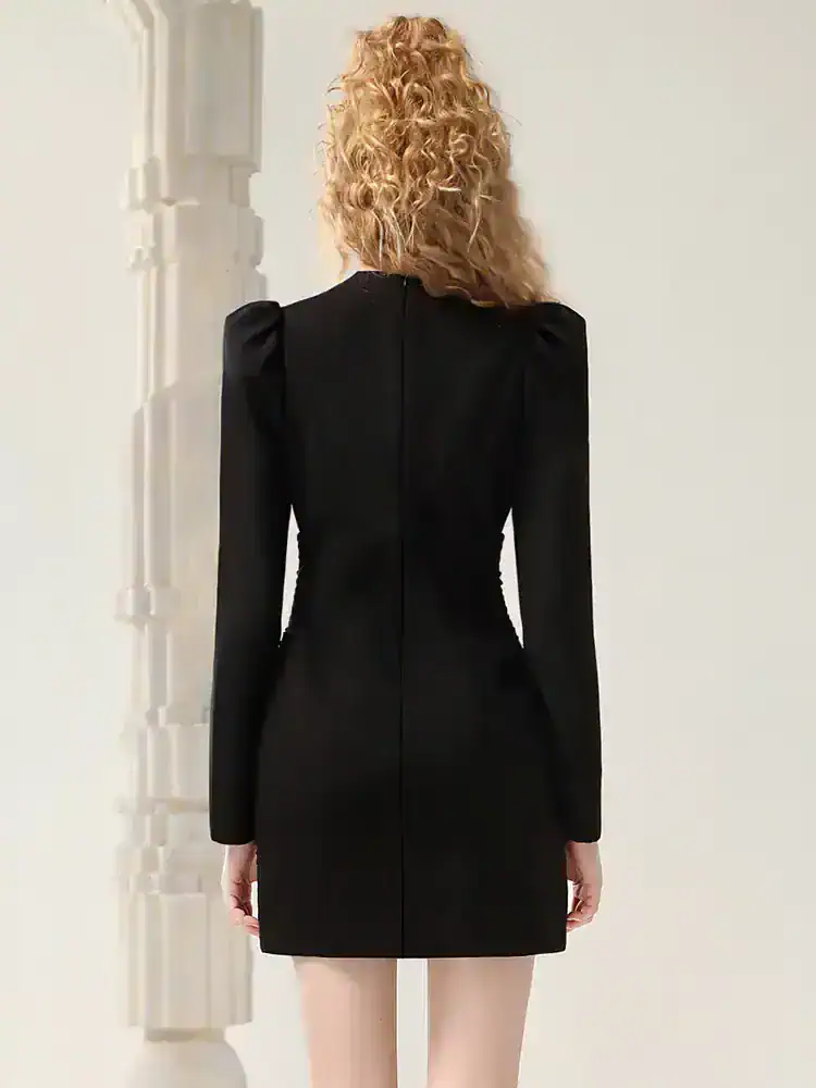 Elegant black dress with structured shoulders and fitted silhouette, perfect for formal occasions or stylish events. Designed with attention to detail for a sophisticated look.
