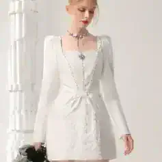 Elegant white formal dress with intricate embroidery and bow detail, perfect for special occasions, stylish wedding guest attire, or upscale events. Features long sleeves, a fitted silhouette, and decorative accessories.