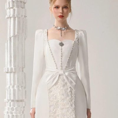 Elegant white bridal dress with floral embroidery and bow detail, perfect for wedding or special occasions. Designed for a sophisticated bridal look with lace accents.