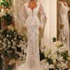 Luxurious white lace wedding dress with intricate embroidery, long sleeves, plunging neckline, and fitted silhouette perfect for bridal elegance and special occasions.