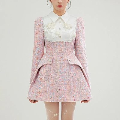 Luxurious pastel pink tweed dress with embroidered floral details, structured design, and playful hemline, perfect for elegant occasions and fashion-forward styling.
