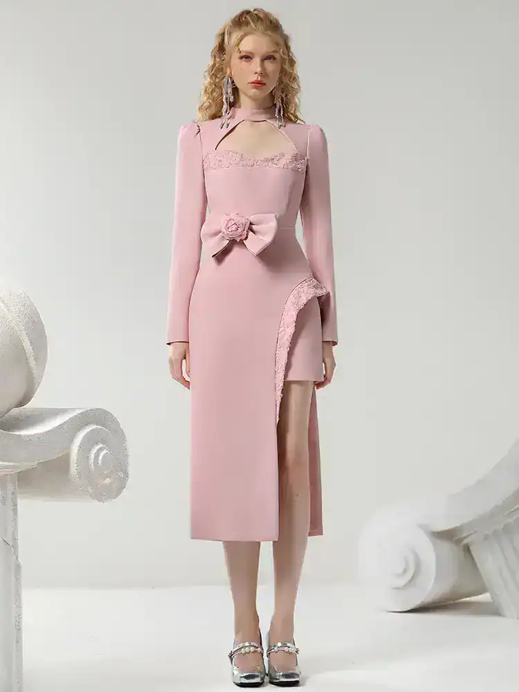 Elegant pink evening gown with floral embellishment, lace details, and high slit, perfect for formal events and special occasions. Suitable for sophisticated fashion and luxury dress shopping.