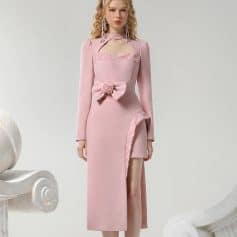 Elegant pink evening dress with lace details, floral bow accent, and thigh-high slit for a stylish look at formal events. Perfect for fashion-forward women seeking luxury and sophistication.