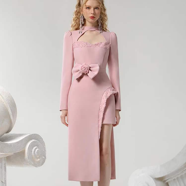 Elegant pink evening dress with lace details, floral bow accent, and thigh-high slit for a stylish look at formal events. Perfect for fashion-forward women seeking luxury and sophistication.