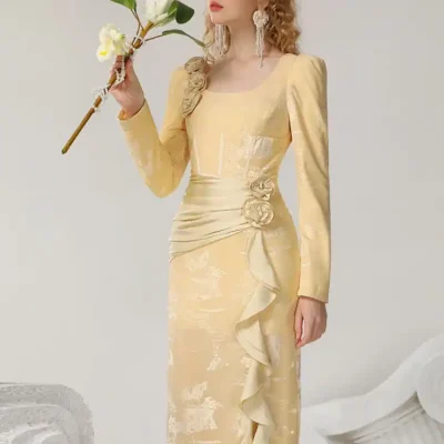 Elegant gold evening gown with floral embellishments and ruffle details, perfect for formal occasions. Designed for sophisticated style at Monalisa Medical Store.
