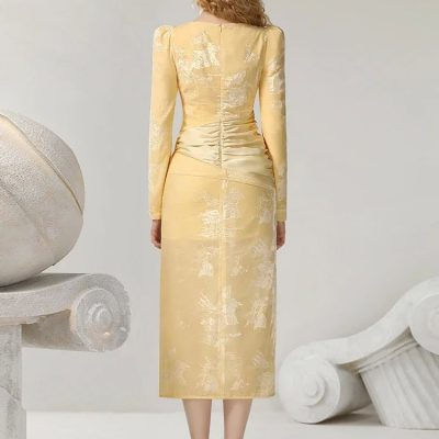 Elegant yellow embroidered dress with long sleeves and ruched back, perfect for formal occasions or fashion events.
