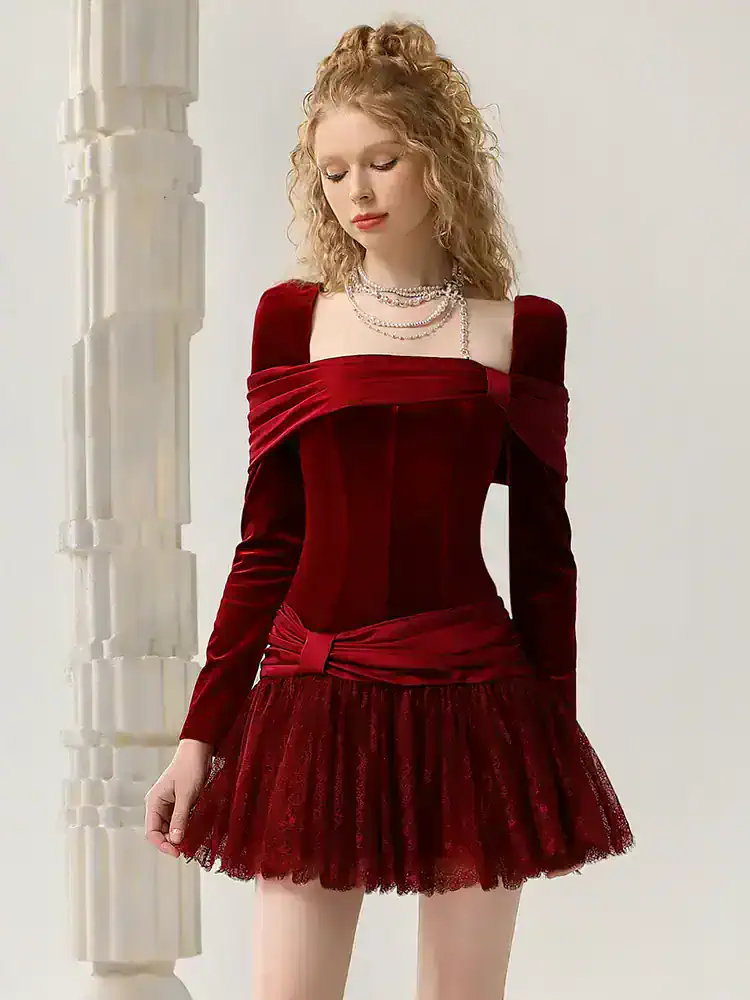 Luxurious red velvet dress with off-shoulder design, fitted waist, and layered tulle skirt, perfect for elegant events and fashion-forward occasions.