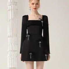 Elegant black dress with embellishments, perfect for formal occasions and fashion-forward events. Designed with intricate details, long sleeves, and a stylish silhouette for a sophisticated look.