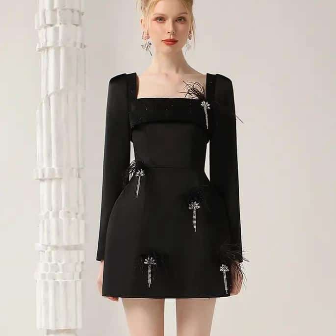 Elegant black dress with embellishments, perfect for formal occasions and fashion-forward events. Designed with intricate details, long sleeves, and a stylish silhouette for a sophisticated look.