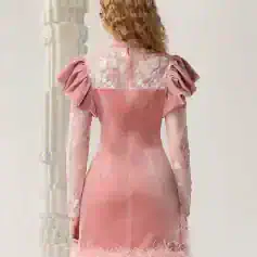 Luxurious pink cocktail dress with embroidered floral details, feather trim at the hem, puffed shoulder design, fitted waist, and sheer long sleeves, perfect for special occasions and elegant events.