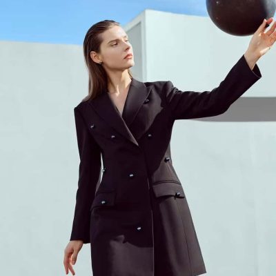 Black blazer dress fashion styling with a black ball, minimalistic outdoor setting. Perfect for modern, elegant women seeking sophisticated clothing and accessories.
