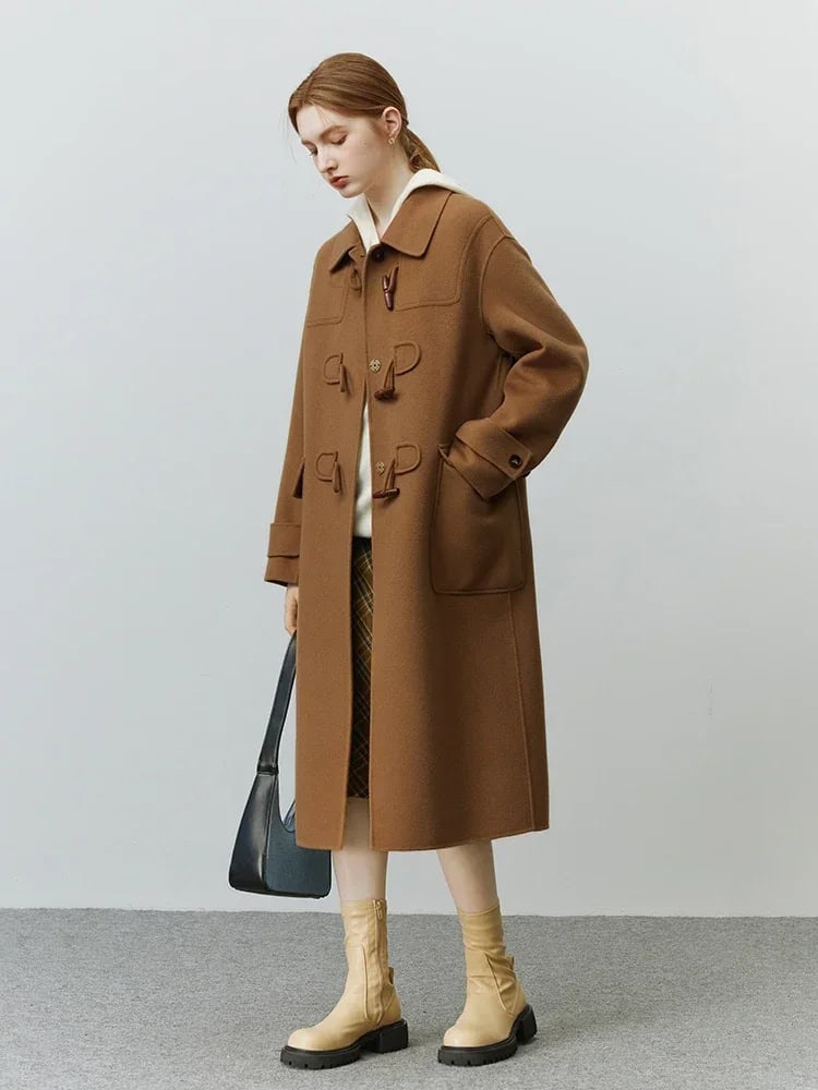 Elegant women's brown coat with toggle buttons, stylish boots, and a black handbag, perfect for fall and winter fashion. Monalisa Store offers high-quality outerwear and accessories for sophisticated looks.