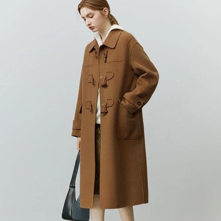 Camel duffle coat with toggle fastenings, layered over a white hoodie, multicolored checked skirt, and accessories, perfect for stylish winter wear from Monalisa Store.