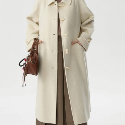 Elegant winter coat in cream wool with oversized collar, perfect for stylish cold-weather fashion. Features toggle buttons and side pockets, versatile and cozy for winter wear.