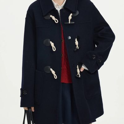 Cozy navy duffle coat with classic toggle closures, ideal for fall and winter fashion, paired with a red sweater and skirt for a stylish, warm look.