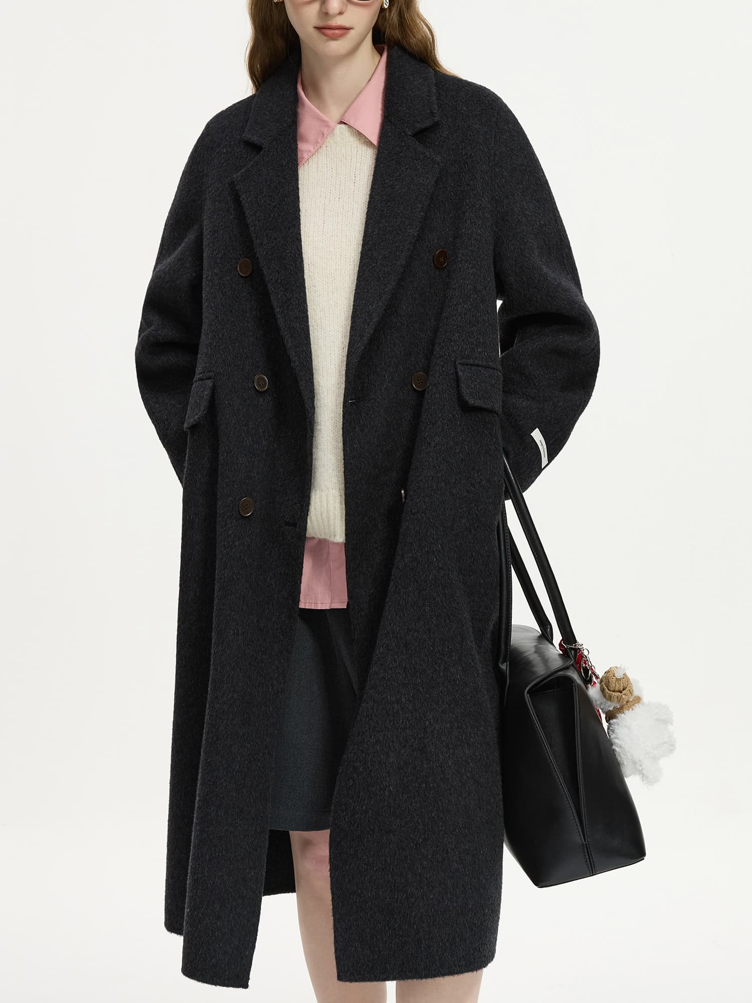 Elegant black wool coat with a classic double-breasted design, perfect for winter fashion and trendy look. Ideal for stylish women seeking high-quality, warm outerwear.