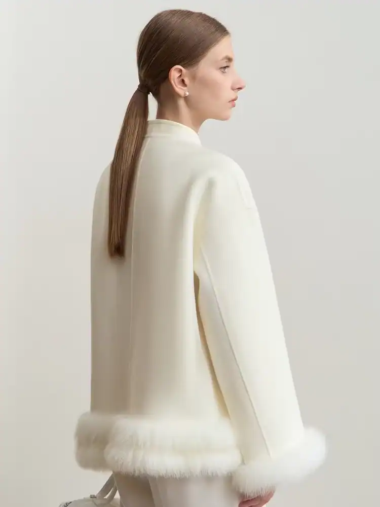 Luxurious white cashmere coat with faux fur trim, elegant and cozy fashion piece for winter, perfect for sophisticated women seeking high-quality outerwear.