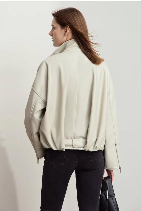 Luxurious beige oversized jacket with zippered cuffs, stylishly draped on a woman with brown hair, perfect for fall and winter fashion.