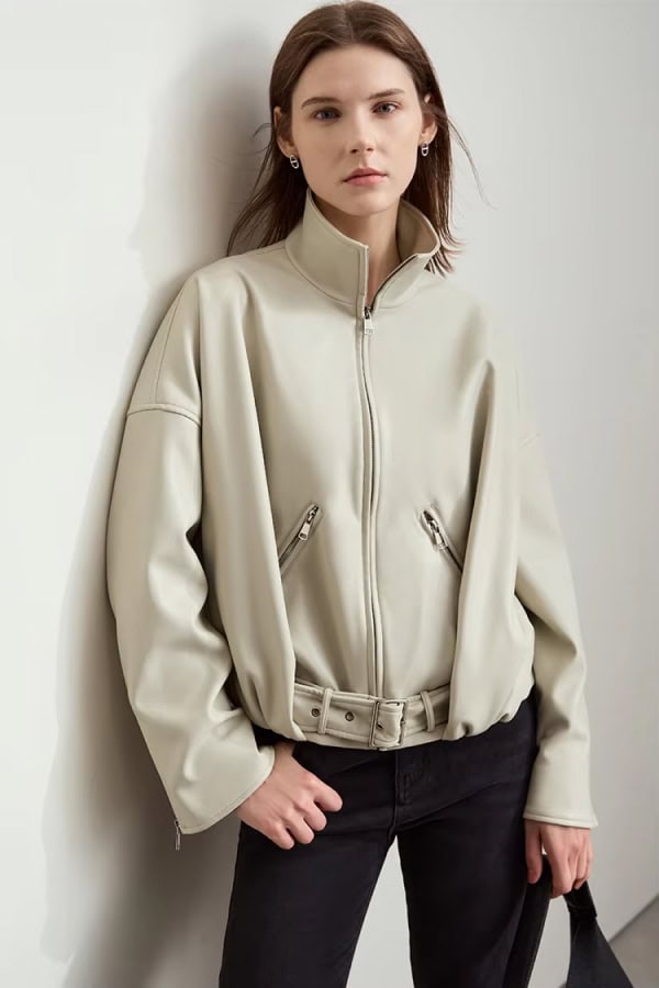 Soft beige faux leather bomber jacket with zippered pockets and adjustable waist, stylish women's outerwear perfect for fall and winter.