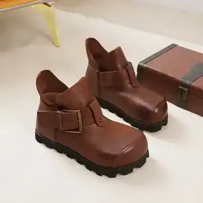 Leather ankle boots with buckle strap for women, stylish and comfortable footwear for casual or formal wear.