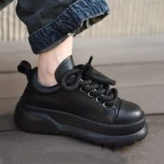 Comfortable black chunky sneaker on a person's foot, featuring a thick sole and stylish design, ideal for casual and trendy footwear. Perfect for fashion-forward individuals seeking comfort.