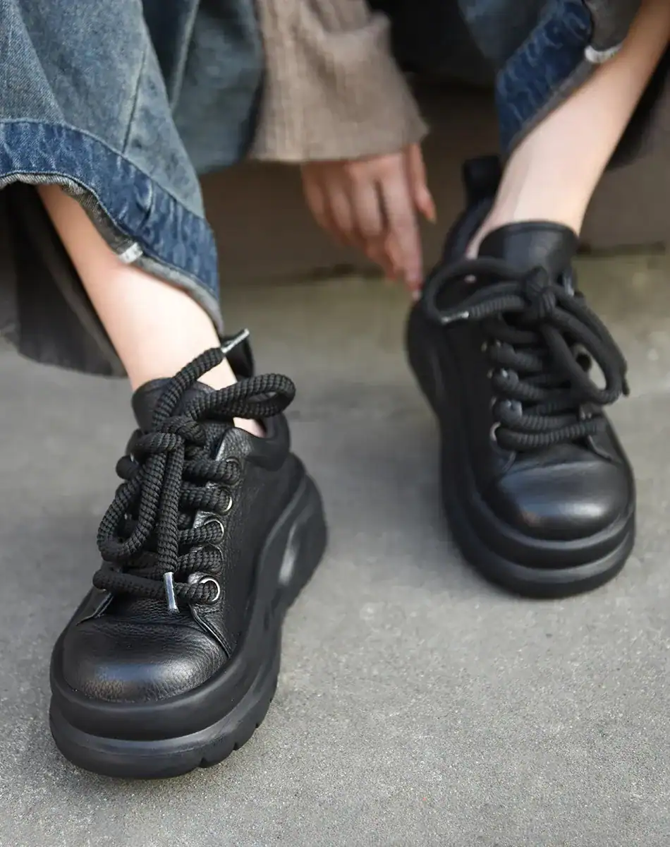 Soft leather black chunky platform sneakers for women, trendy fashion footwear with thick soles and lace-up design.