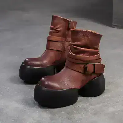 Black chunky-soled leather ankle boots with buckle straps, stylish and durable footwear ideal for fashion-forward individuals. Perfect for everyday wear and statement looks.