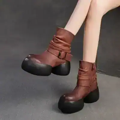 Unique fashion-forward platform boots with chunky black soles and brown leather upper, featuring buckle accents, perfect for making a bold style statement.