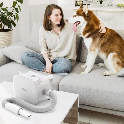 Gentle pet oxygen therapy device for dogs in a cozy home setting with a woman and her husky, promoting pet wellness and health through reliable respiratory support.