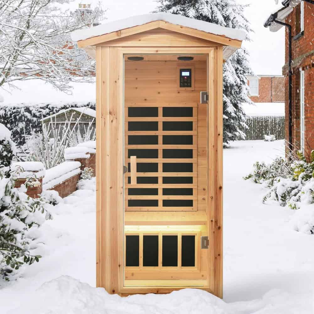 Compact outdoor sauna in a snowy garden, made of natural wood with modern black accents, perfect for relaxing and wellness in winter.