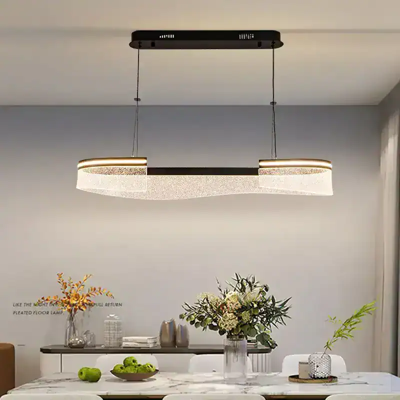 Modern LED pendant light fixture hanging above a stylish dining table with floral centerpiece in a contemporary home interior.