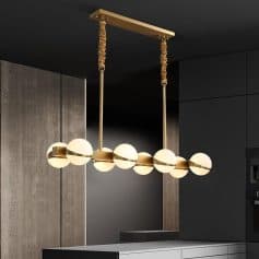 Modern chandelier with globe lights hanging over a contemporary kitchen island in a stylish home interior.