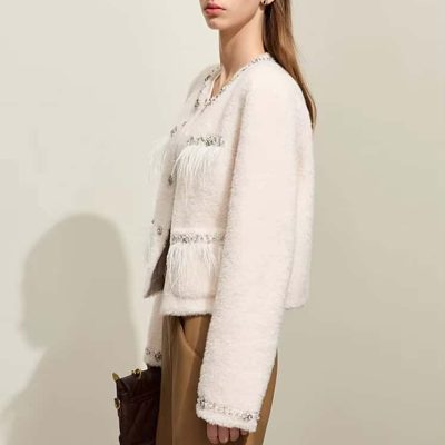 Luxury women's fashion by Monalisa Store, elegant white textured jacket with fringe details, chic beige skirt, fashionable ensemble, sophisticated style, ideal for modern women, Monalisa Medical approved.