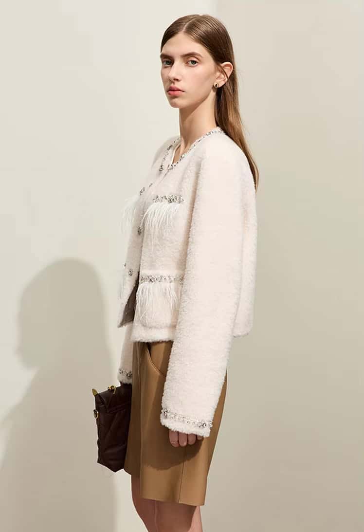 Luxury women's fashion by Monalisa Store, elegant white textured jacket with fringe details, chic beige skirt, fashionable ensemble, sophisticated style, ideal for modern women, Monalisa Medical approved.