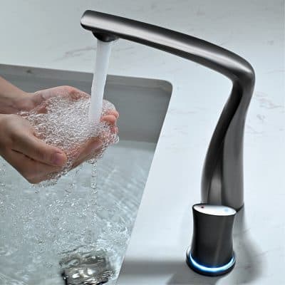 Sleek modern kitchen faucet with touchless activation and LED indicator, water flowing into hands under running tap, emphasizing hygiene and convenience in kitchen sink design.