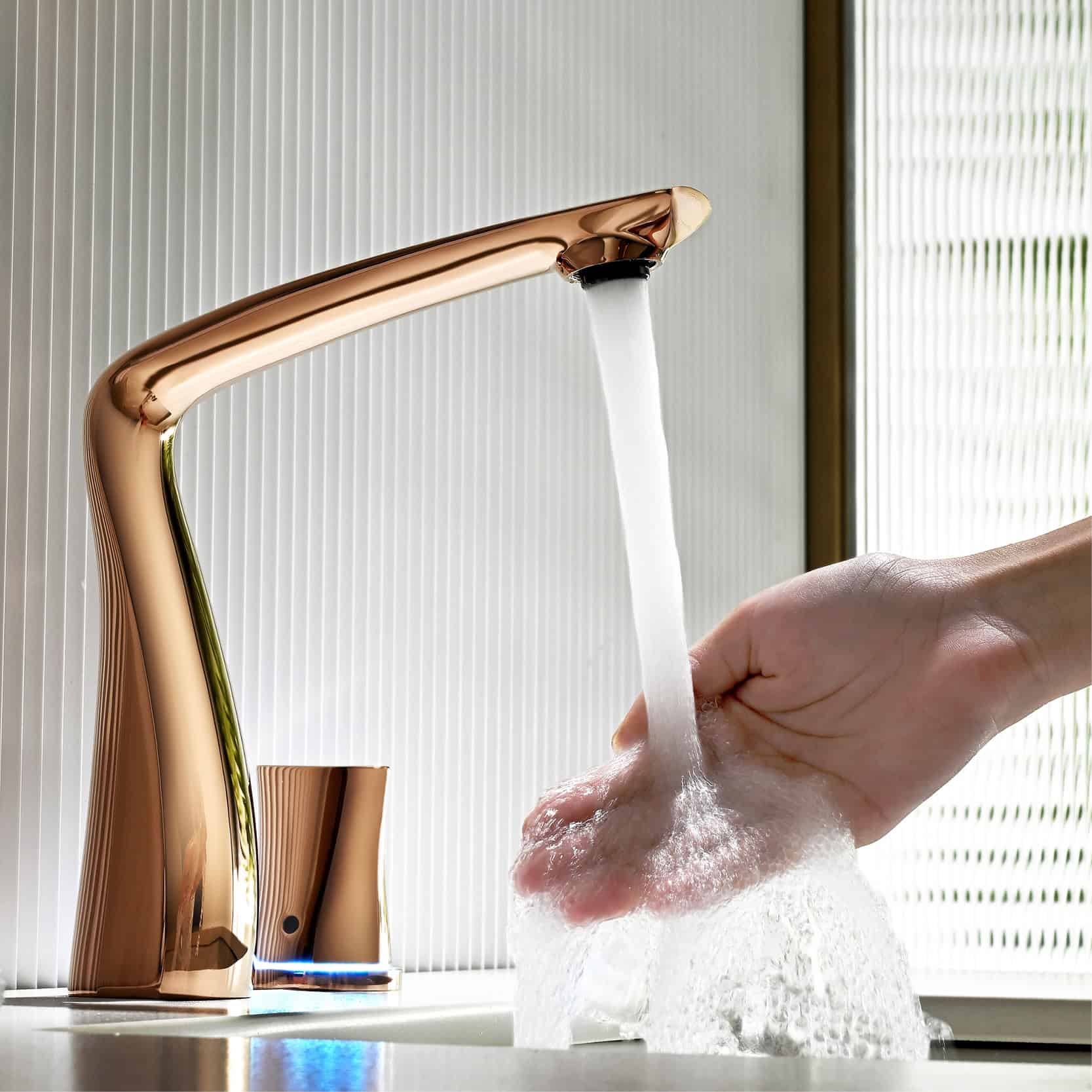 Sleek rose gold faucet with running water in a modern bathroom setting.