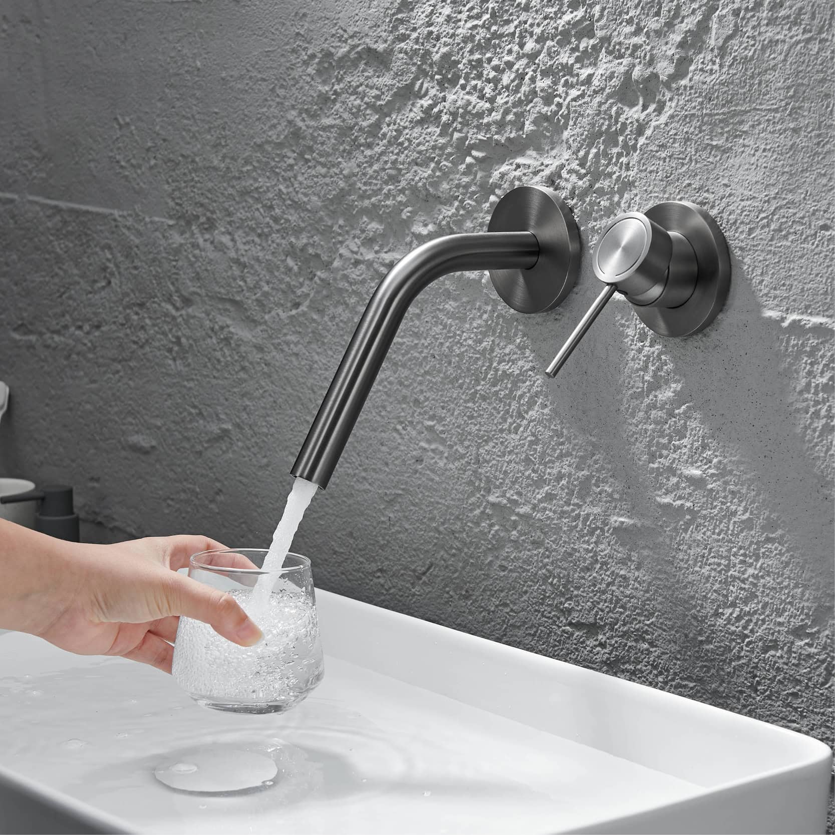 Modern stainless steel wall-mounted faucet in a contemporary kitchen or bathroom setting, with a hand filling a glass with water. Focus on sleek design, durable material, and functional hygiene features for home or commercial use.