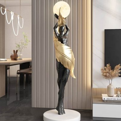 Elegant gold and black human figurine sculpture holding a moon, stylish decor for Monalisa Medical store, ideal for modern interior design, decorative art piece enhancing space aesthetics.